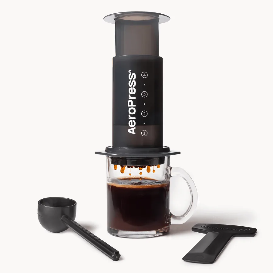 AeroPress Original coffee press beside a glass of coffee