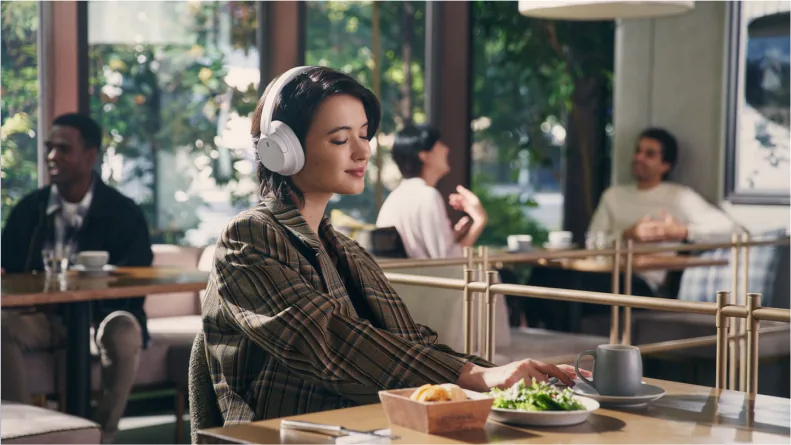 Sony lifestyle image shows seated listening in a shared space.