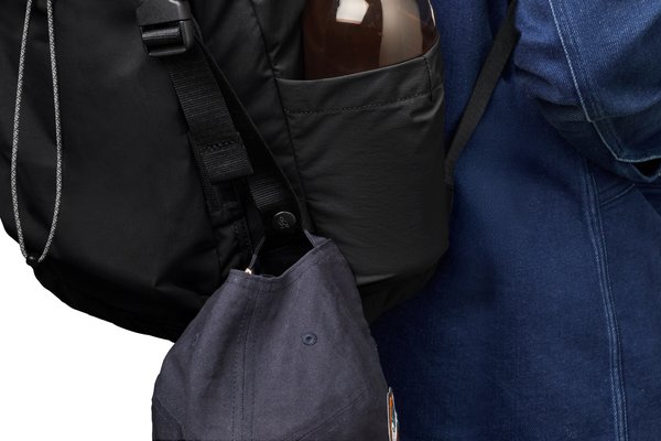 Bellroy Cinch Backpack: A bottle shown at the side, in a manufacturer demonstration.