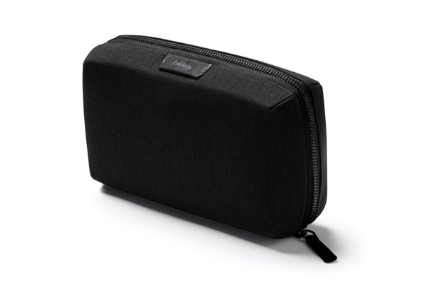 Black Bellroy Tech Kit zipped closed on a white background