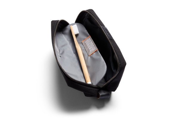 The standard Toiletry Kit open with a manual toothbrush resting in its separate internal sleeve