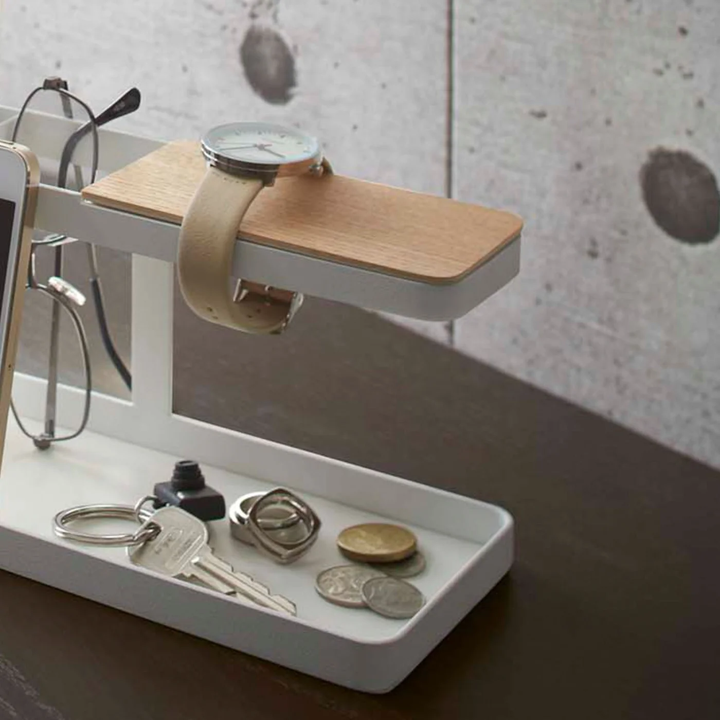 Close view of a watch hanging from the Deskbar above keys in the tray