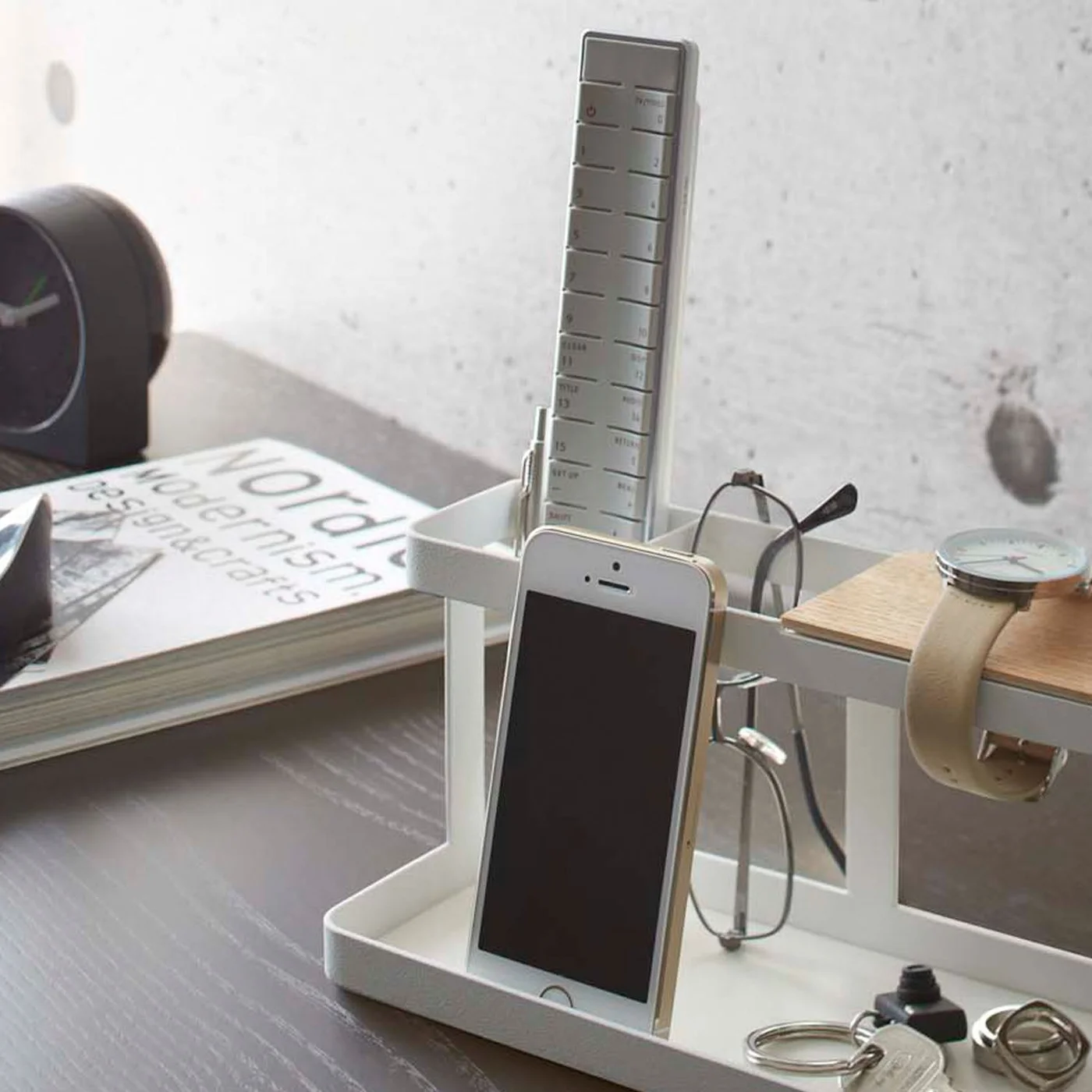 Close view of a phone and glasses standing against the Deskbar