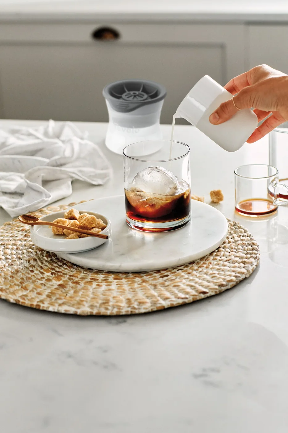Manufacturer serving scene with a largeice sphere in a tumbler.