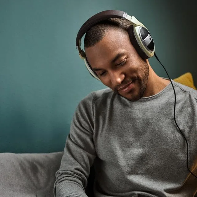 Indoor listening scene illustrates the intended setting; connected device not included.