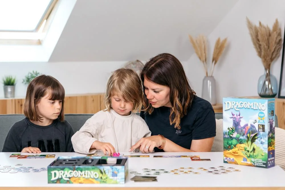 Publisher-staged family play shows individual landscapes spread across a table.