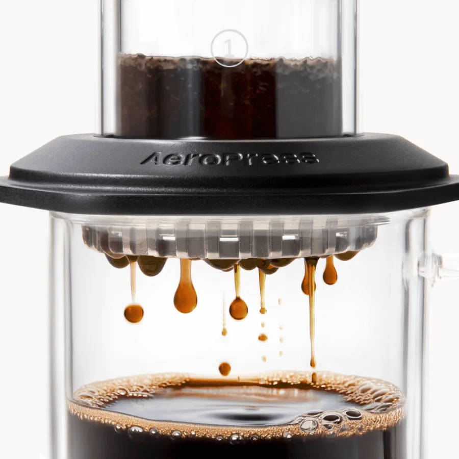 Coffee passing through the perforated filter-cap assembly during brewing.