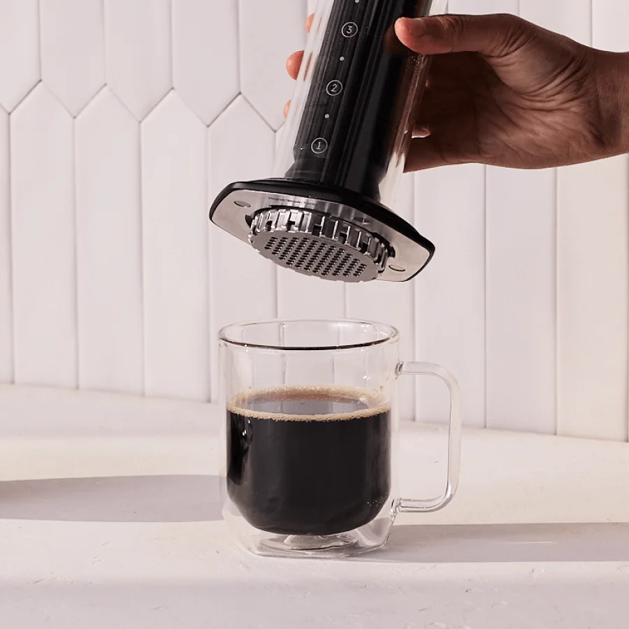 Removing the brewer after pressing into a sturdy mug; do not press on delicate glassware.