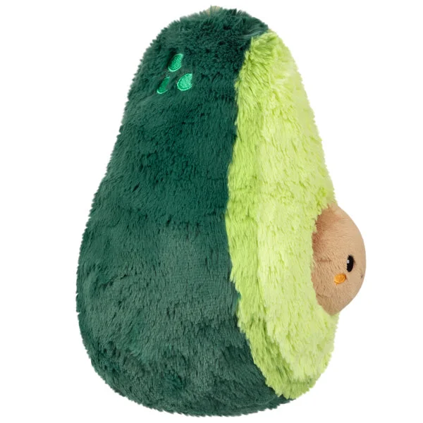 Side view of the rounded avocado plush and projecting smiling stone.