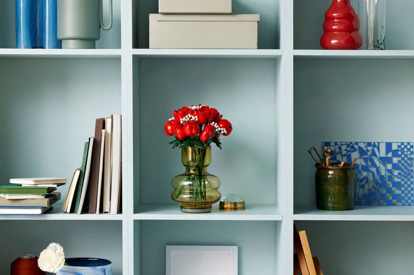 Bouquet in a display vase on a shelf; the vase and furnishings are props.