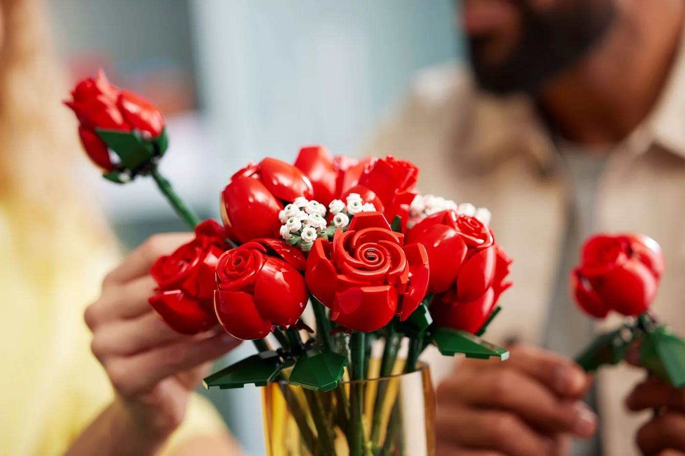 Hands arranging the finished roses in a separately supplied vase.