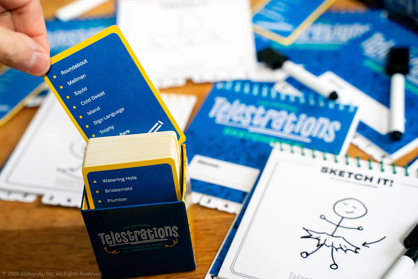 Drawing and guessing cards beside a reusable sketchbook.