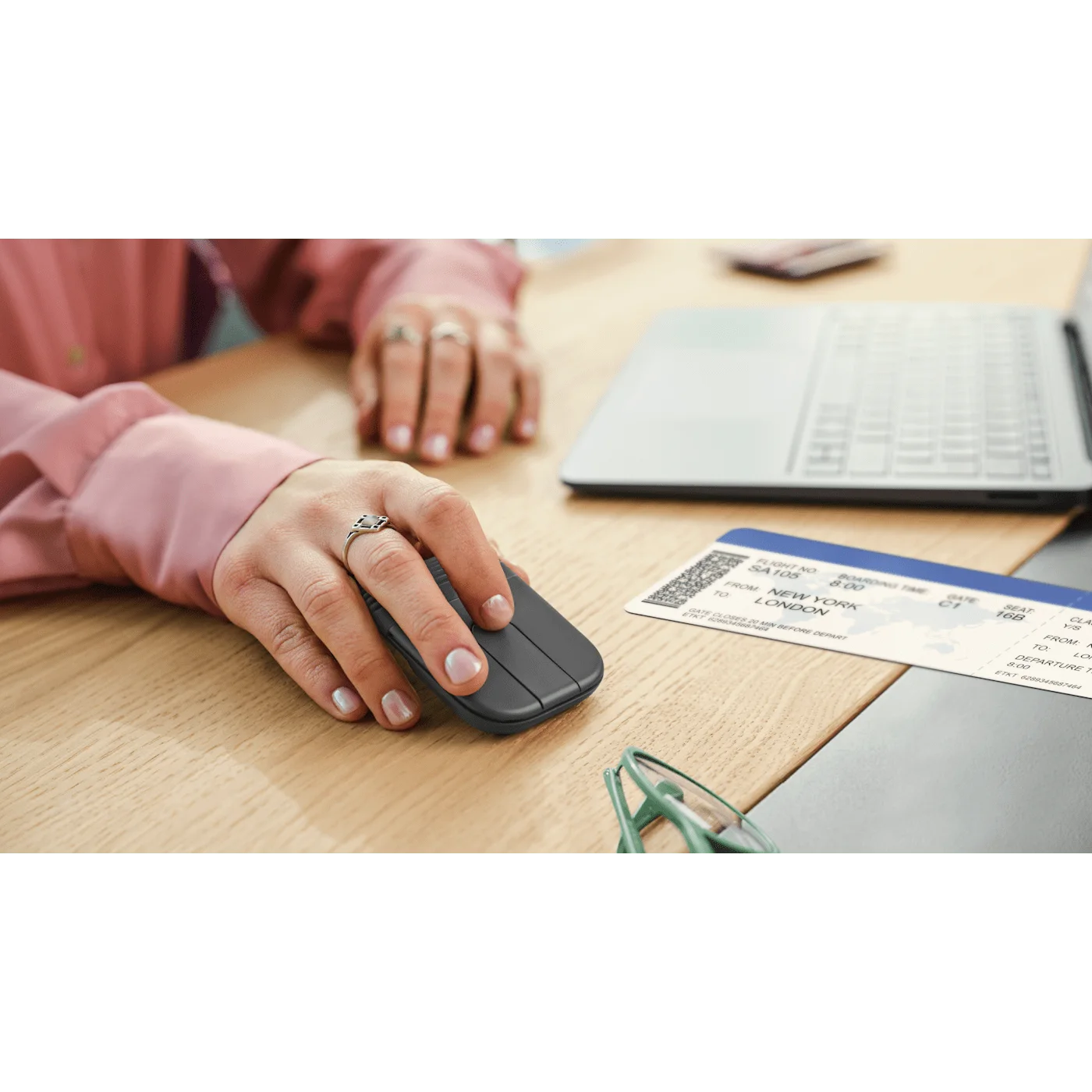 Open mouse used at a table beside a laptop; other objects are separate.