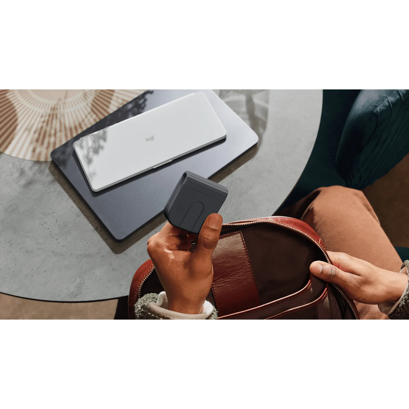 Folded mouse carried in a bag alongside separate mobile devices.
