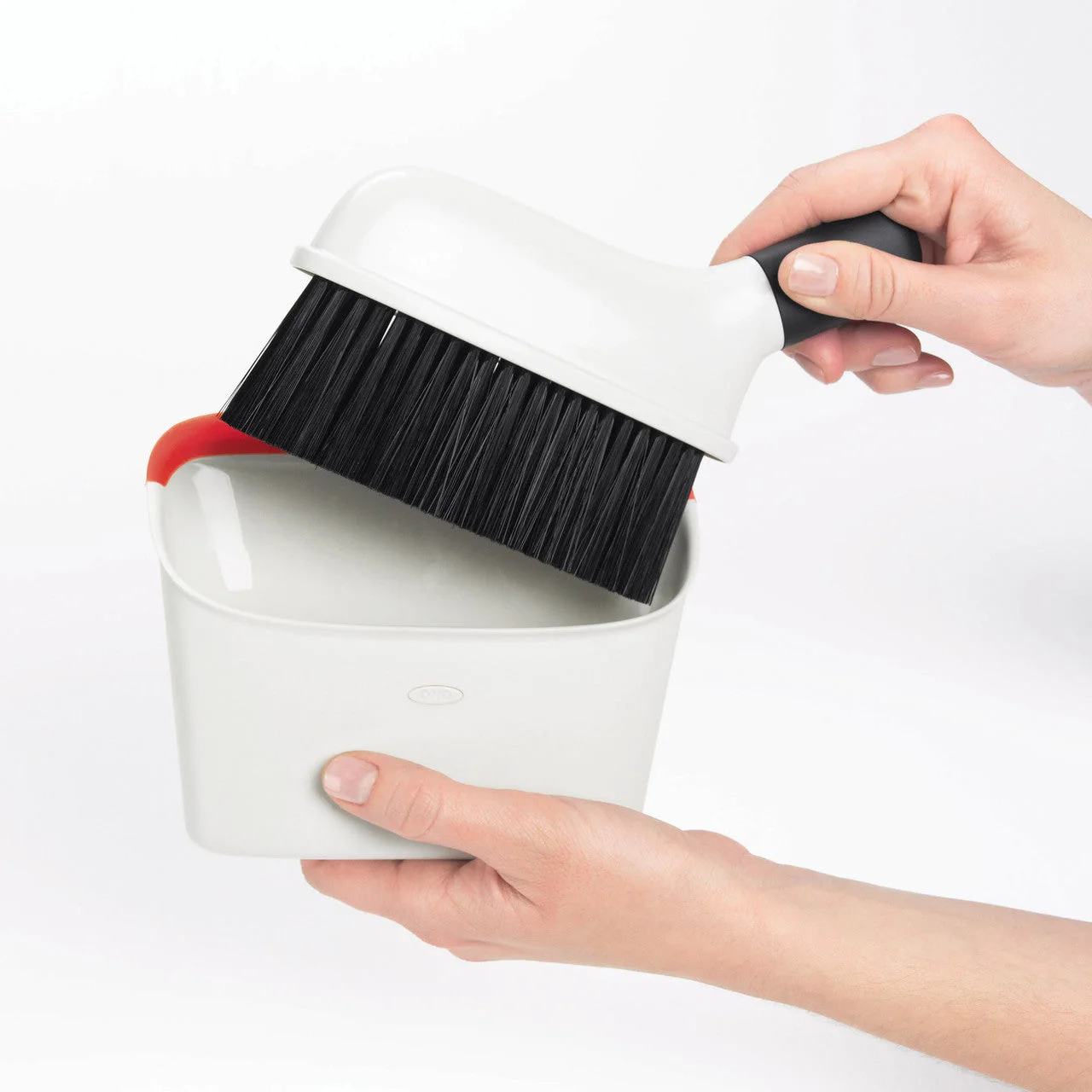 The brush being returned to its clip-in storage position.