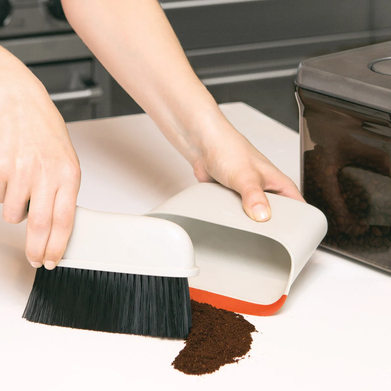 Sweeping a small dry coffee spill; sweeping is not disinfection.