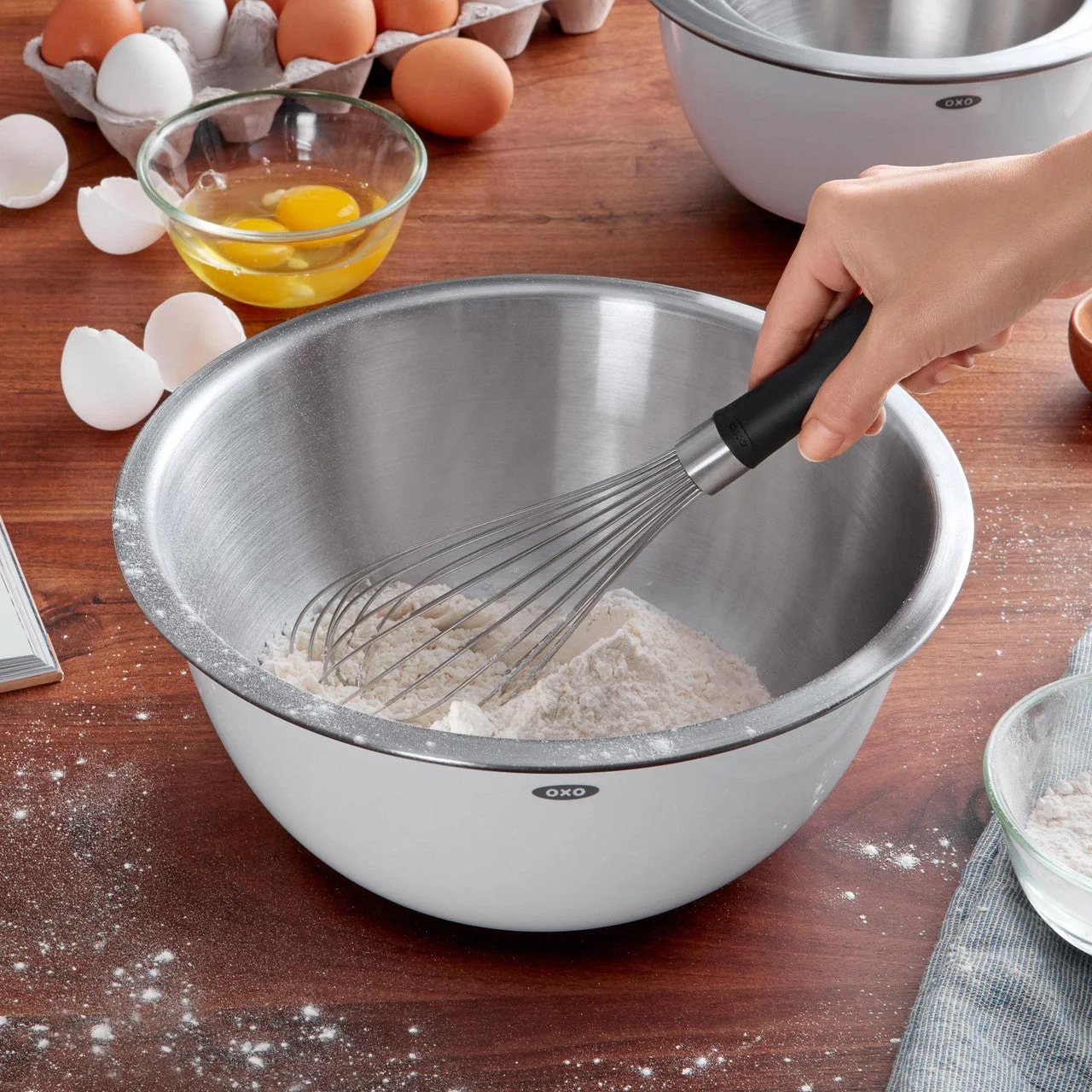 Manufacturer reference shows the handle and whisk moving through flour in a bowl.