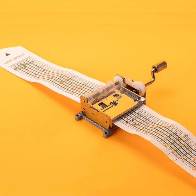 Maker demonstration shows punched paper passing through the hand-cranked mechanism.
