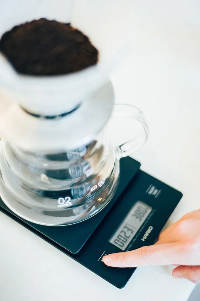 Maker scene of a dripper and server on the scale; brewing equipment is separate.
