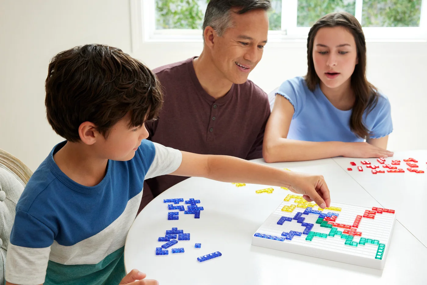 Maker example of players studying the tile layout; local packaging and extras can differ.