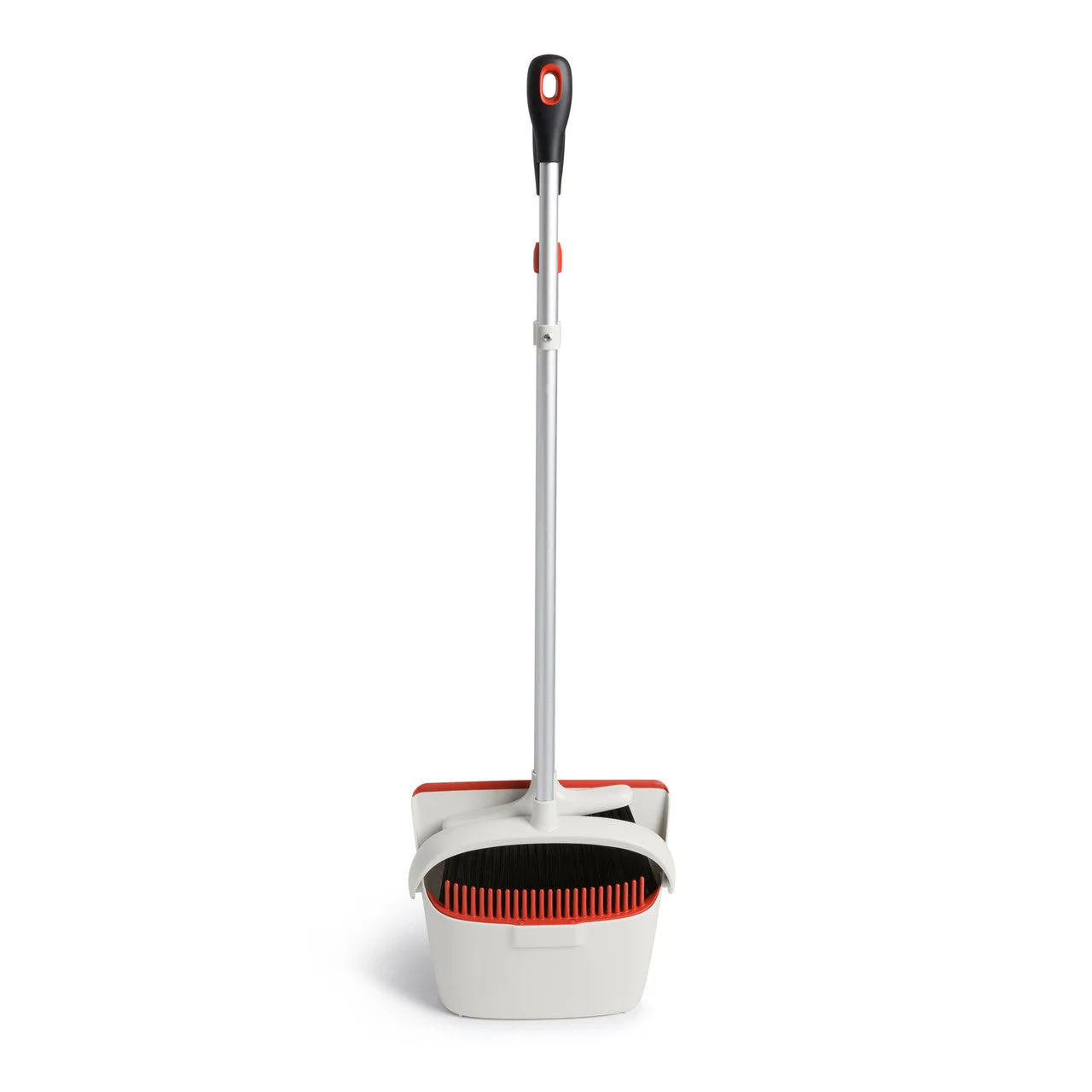 Dustpan pivots upright around collected debris for carrying.
