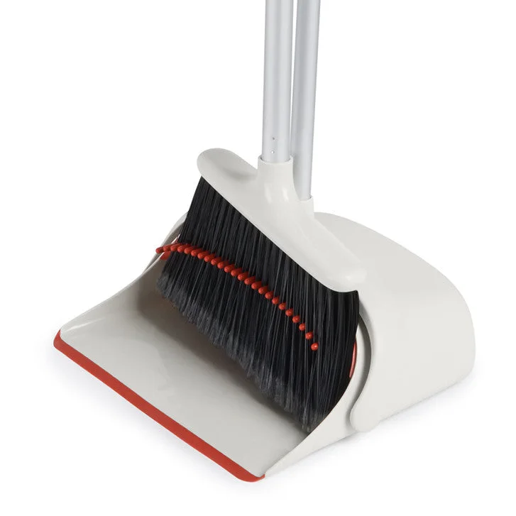 Pan's inner teeth help comb loose debris from the broom.
