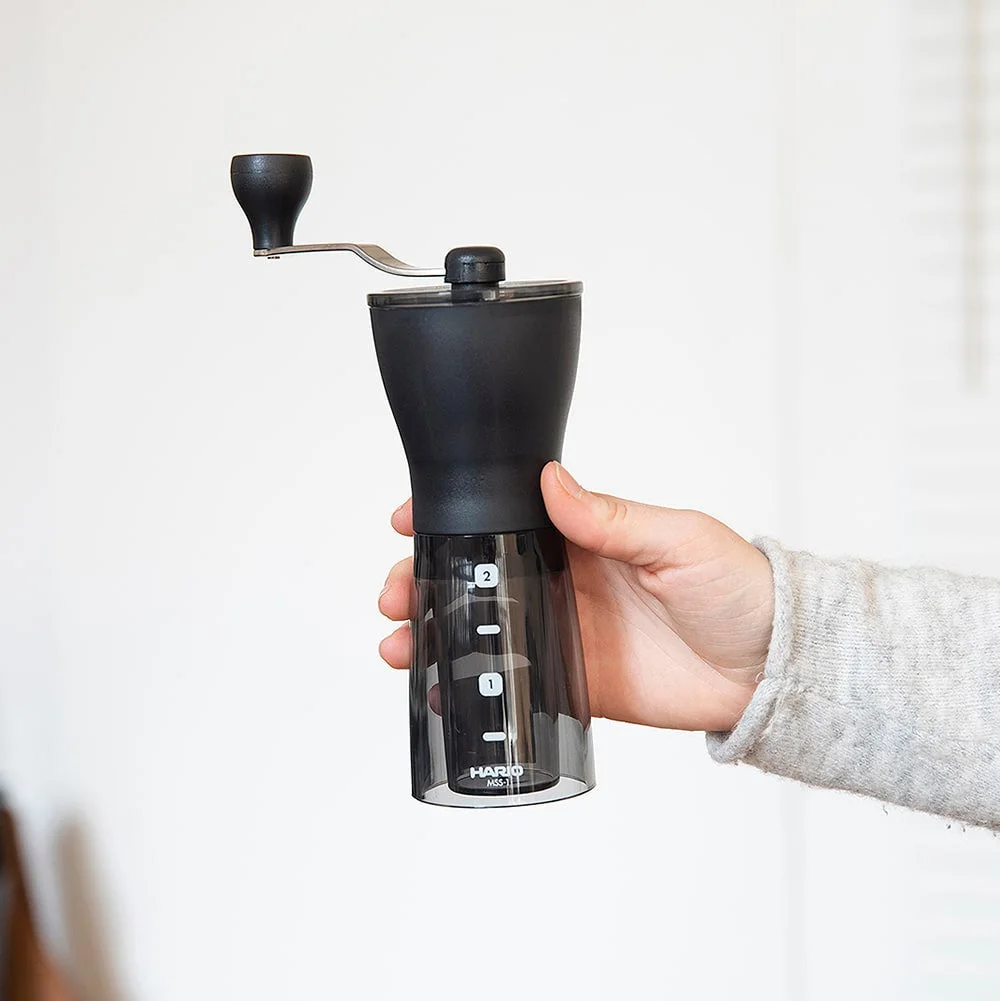 Hand-held product view gives context for the grinder's compact form.