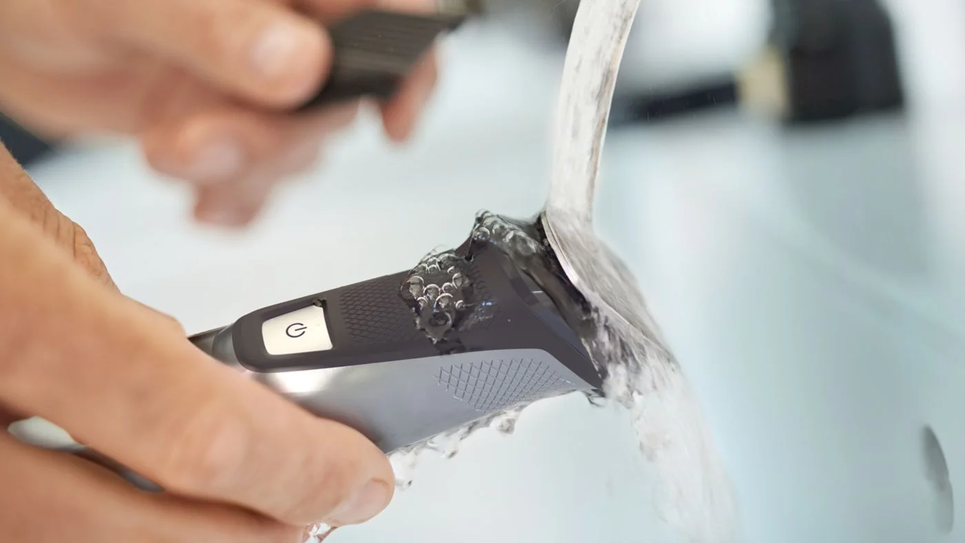 Maker illustrates rinsing the waterproof trimmer; charging equipment must stay dry.