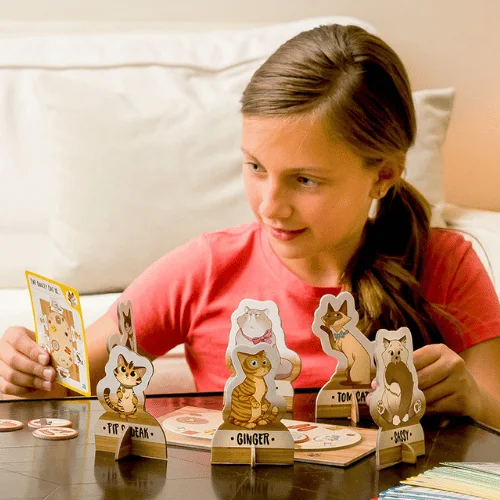 Child reading a Cat Crimes clue card beside the arranged board