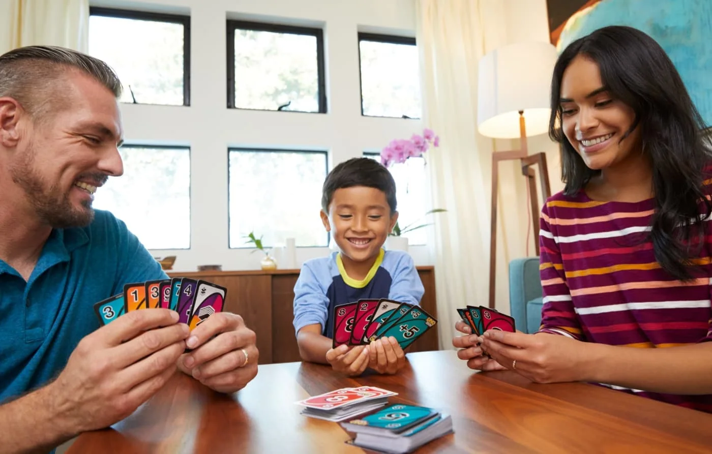 Manufacturer reference scene shows a family playing the double-sided deck.