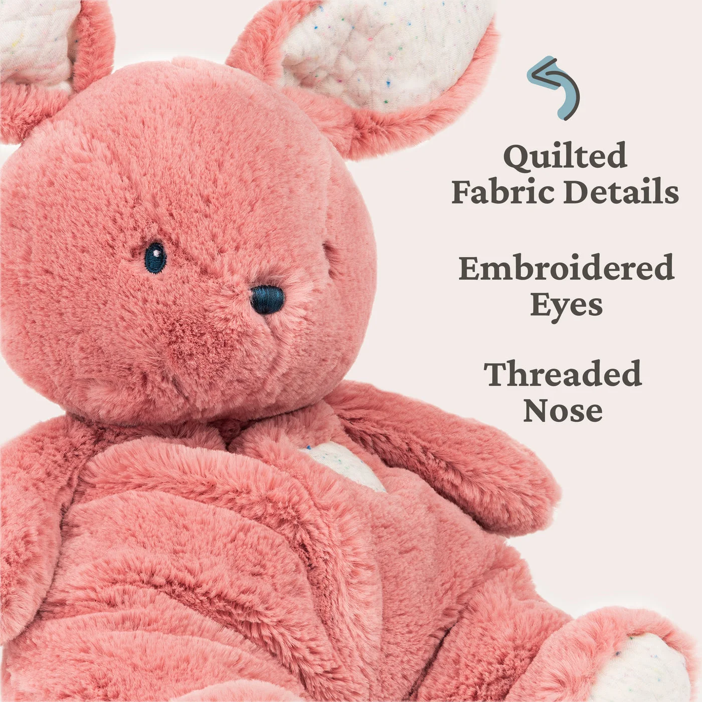 Close-up of embroidered facial details and quilted fabric.
