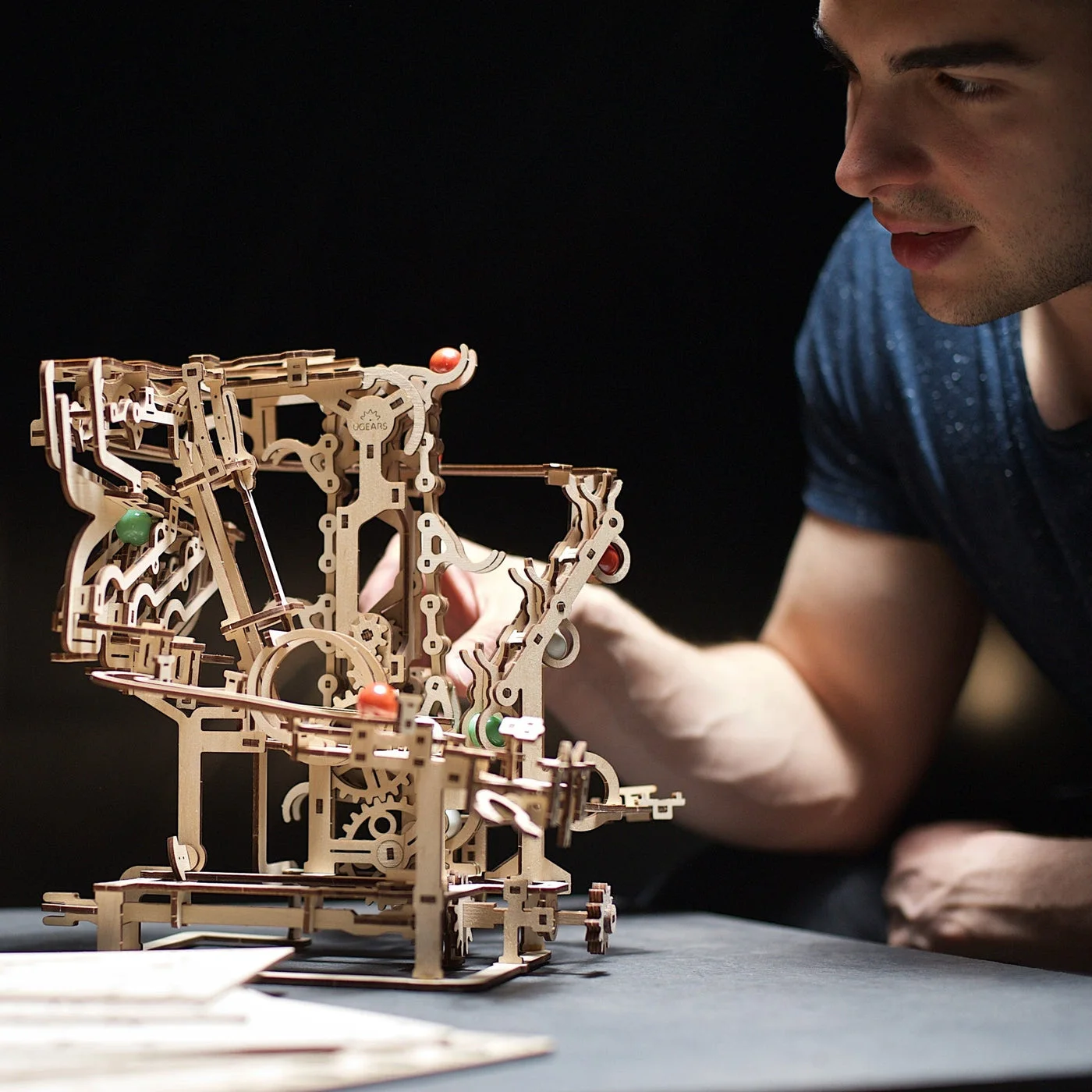Staged maker reference of a person examining the assembled marble run.