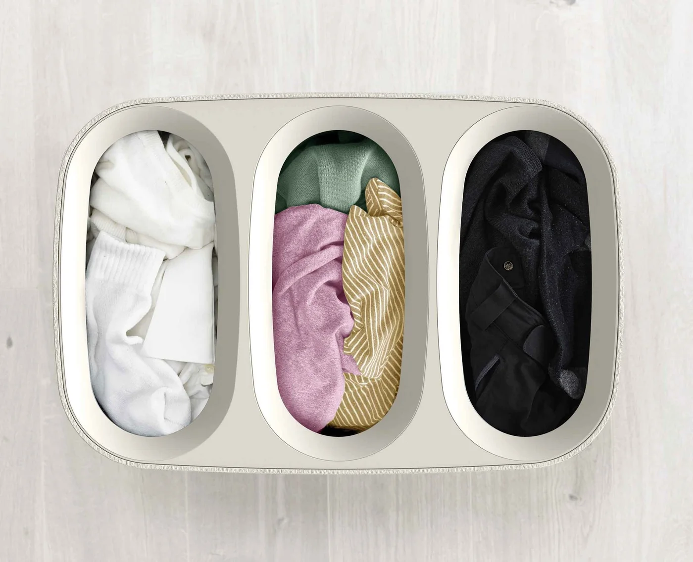 Three separate 30-litre bag compartments shown from above; clothes are props.