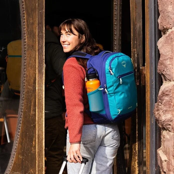 Side-pocket use on an alternative blue26+6 model; bottle and clothing are not included.