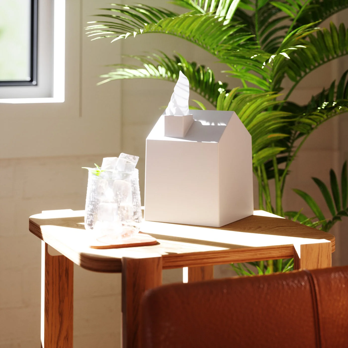 A table scene shows the house-shaped cover beside everyday objects.