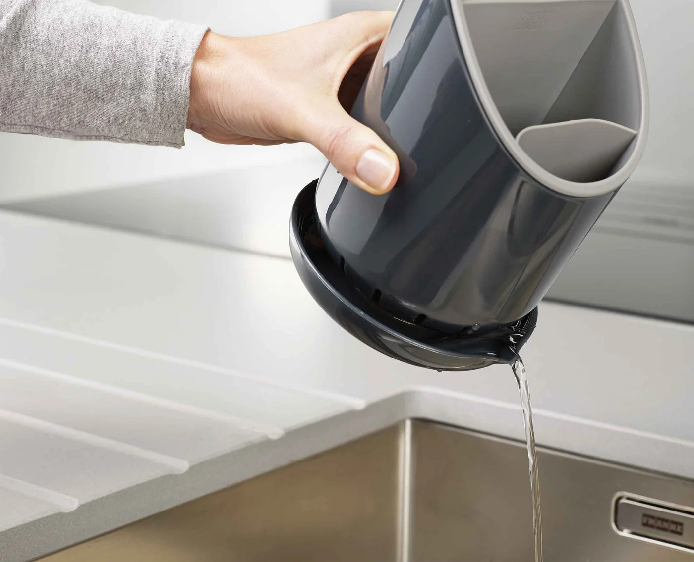 Maker demonstrates pouring collected water from the base saucer.