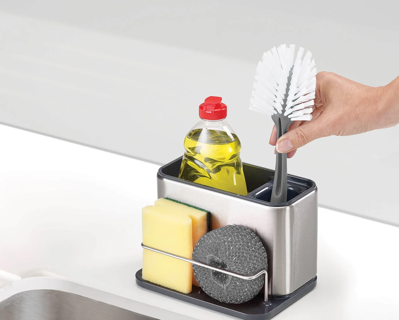 Maker-staged sinkside arrangement shows the brush and bottle compartments.
