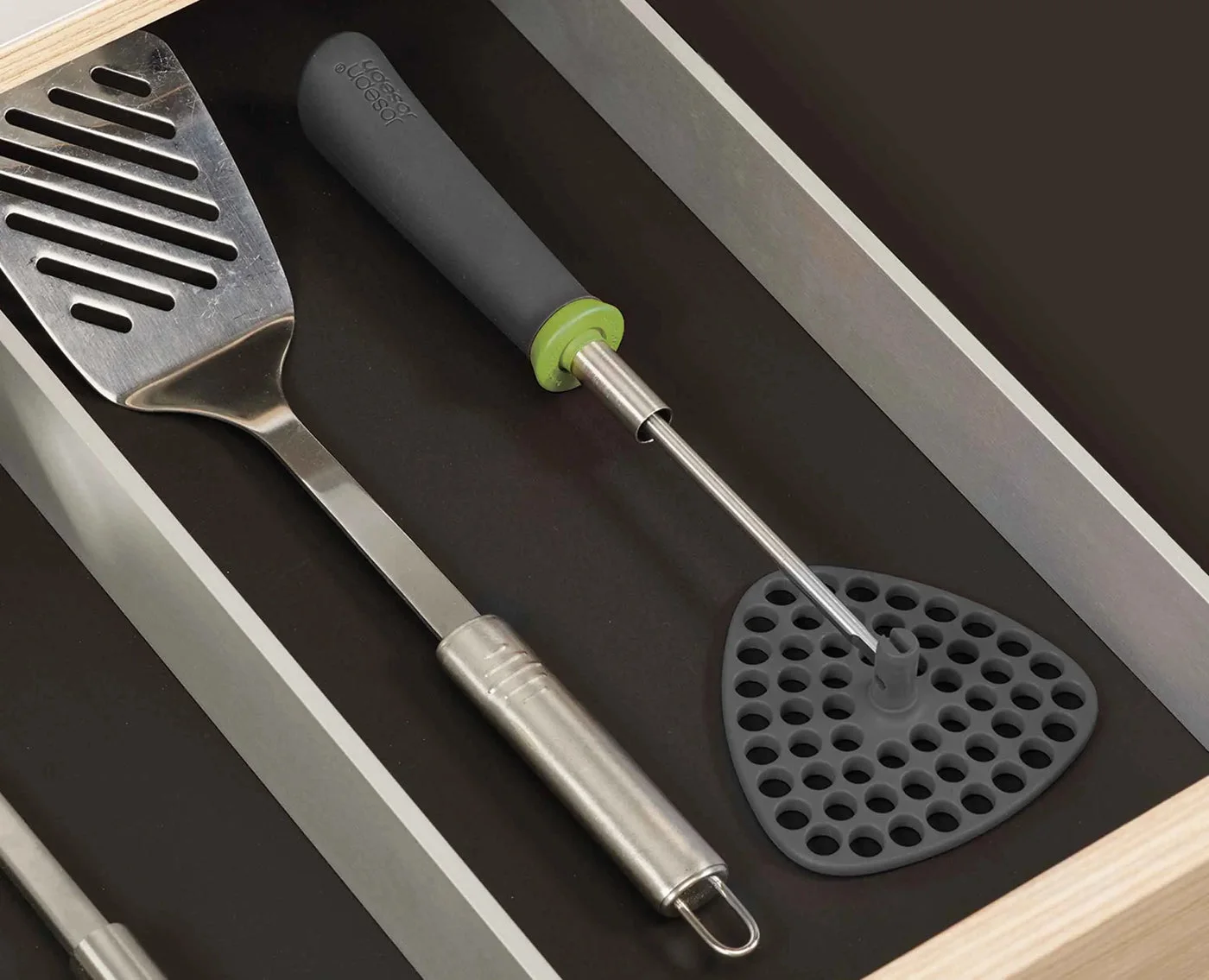 Flat-folded head alongside the shaft in a utensil drawer;other utensils are not included.