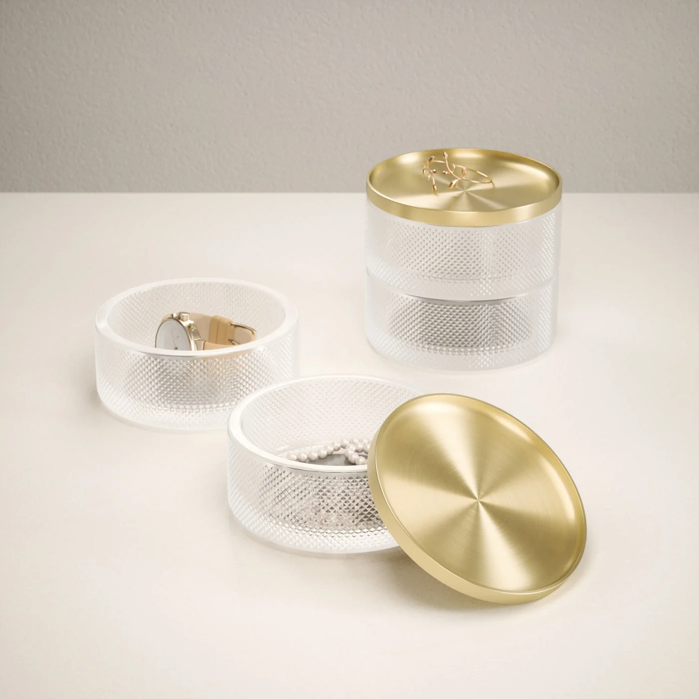 The stackable glass compartments and brass-finish lid shown separately.