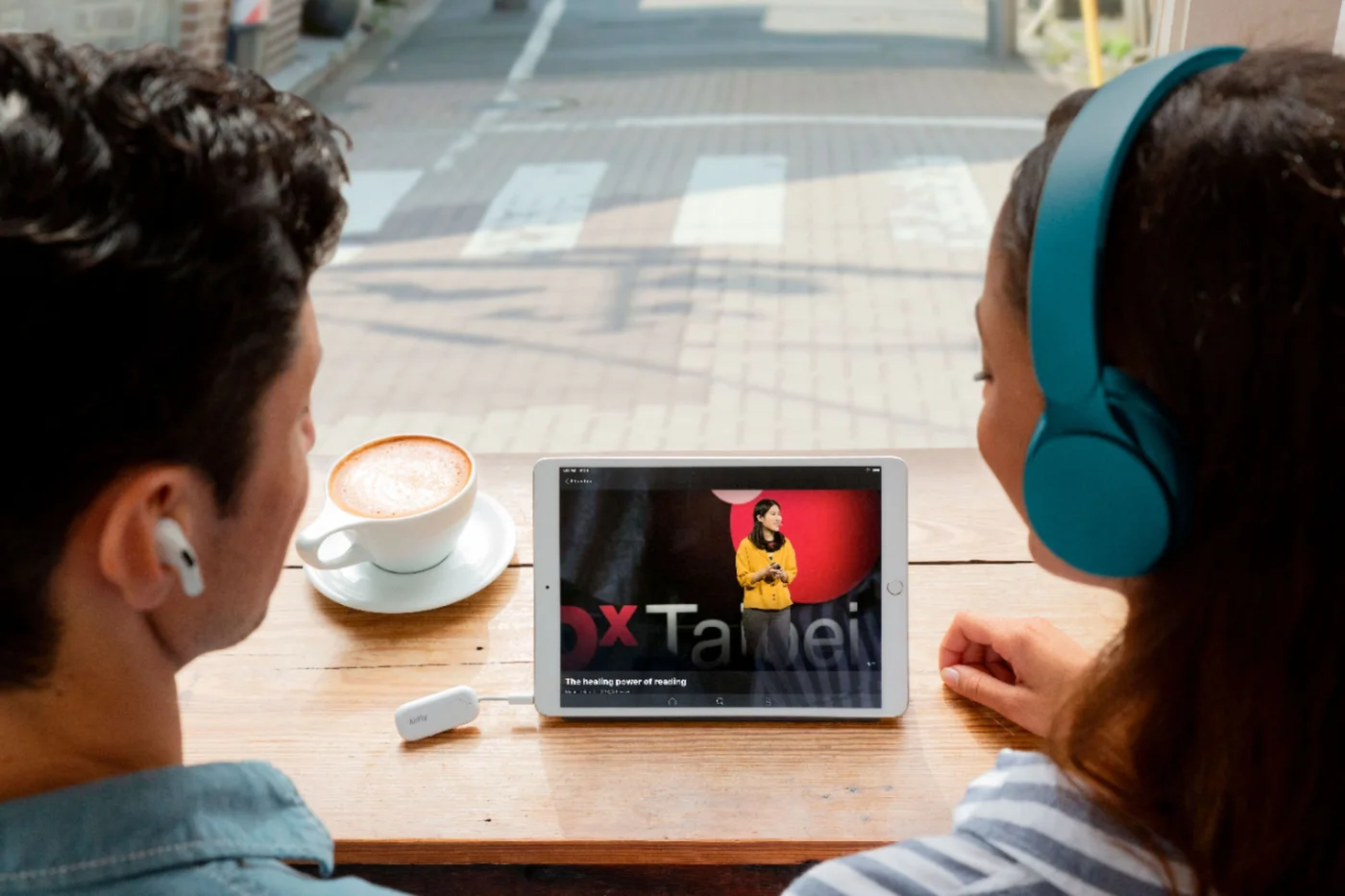 Two listeners sharing one compatible source; both headphone sets require pairing.