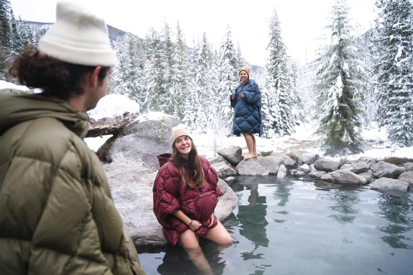 Outdoor lounging with the Down poncho illustrates stationary camp use, not waterproof protection or measured warmth.