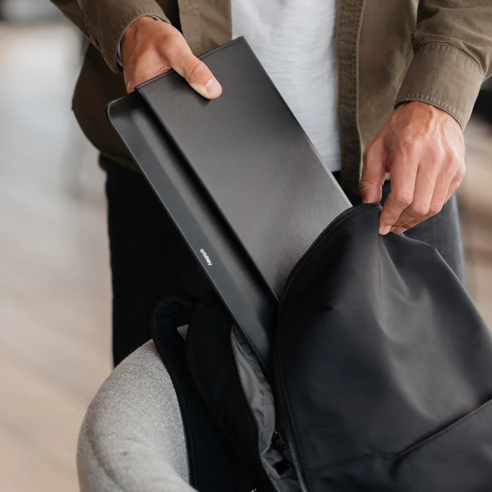 Sleeve sliding into a bag; bag and laptop are not included.