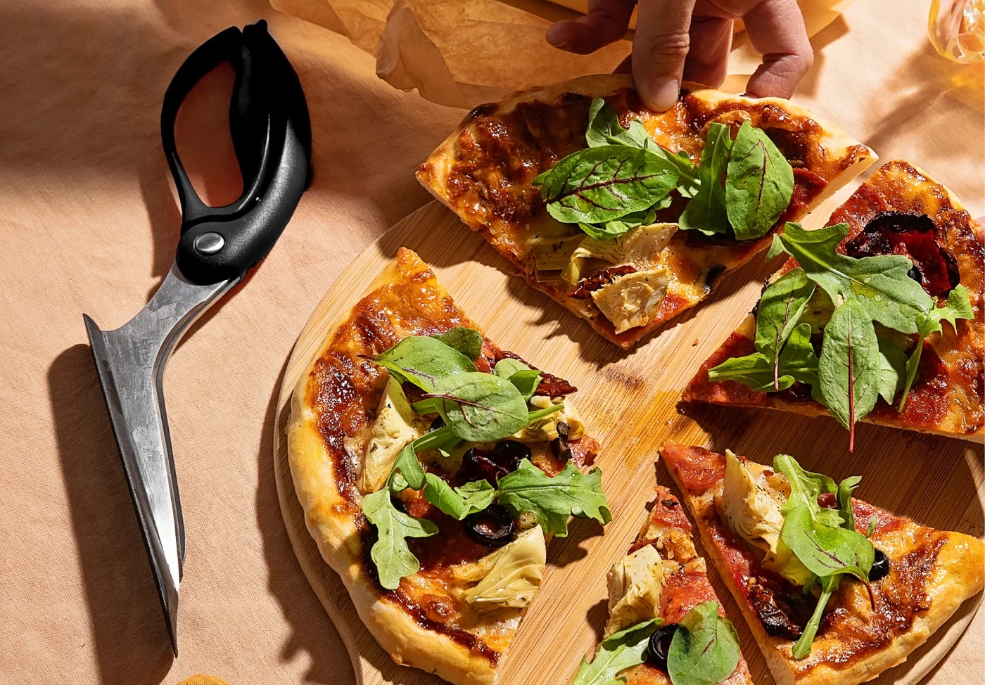 Black-handled Scizza in a styled serving scene, not an additional included tool.