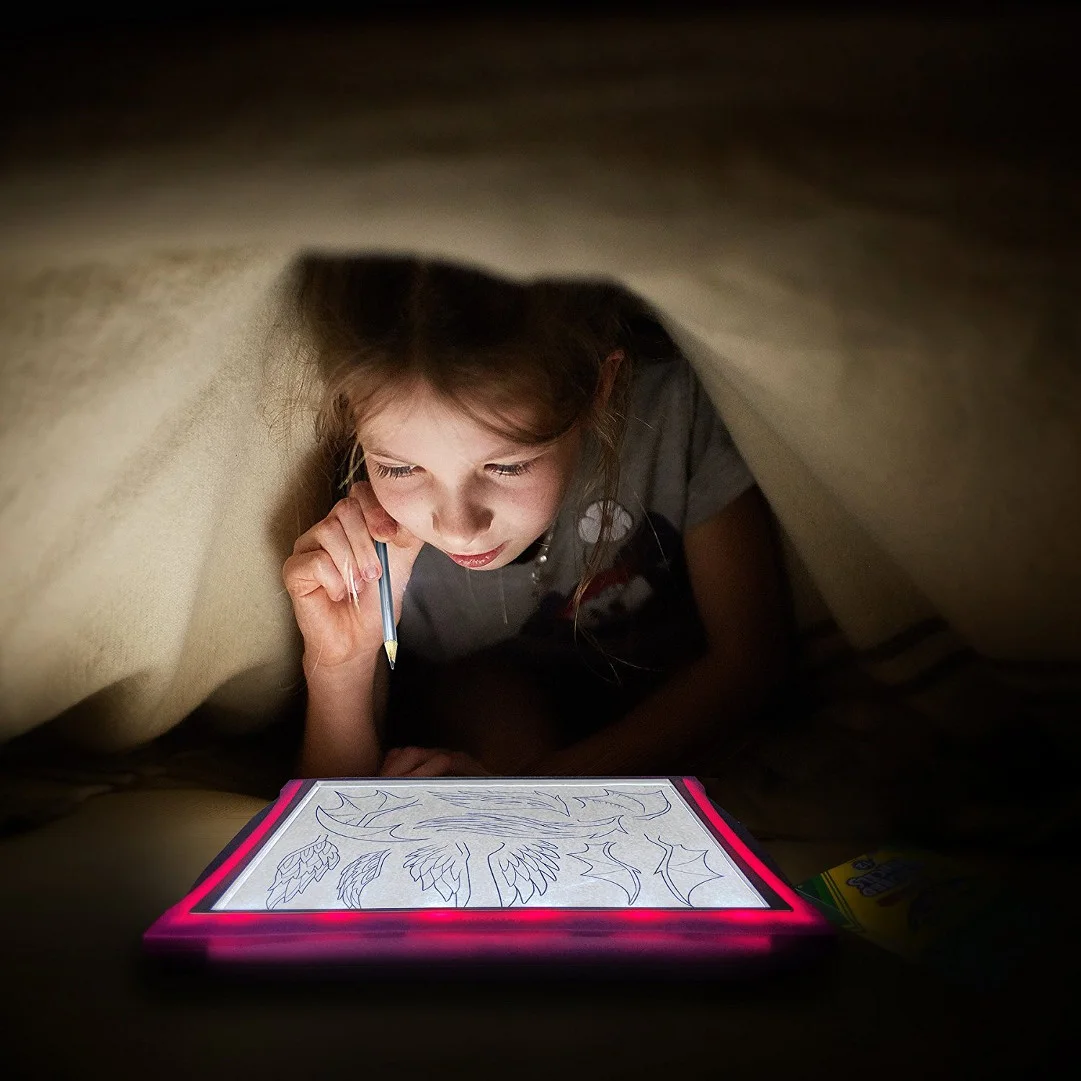Manufacturer example of a child using the illuminated paper pad; not our test.