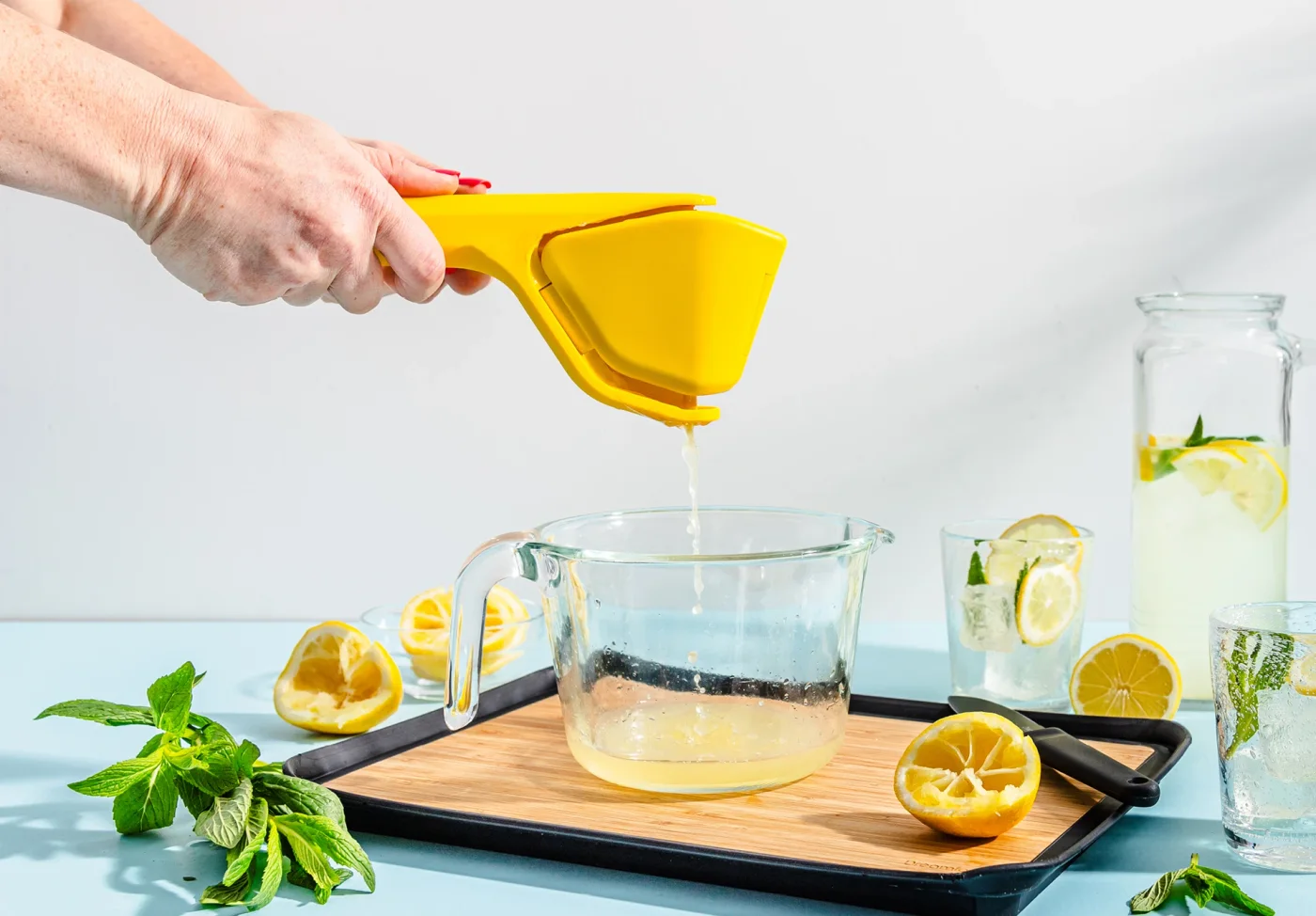 Selected yellow Lemon Fluicer directing juice into a vessel; fruit and glassware are separate.