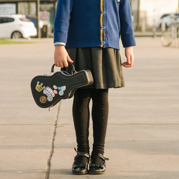 Carrying demonstration with a sticker-decorated case; clothing and scene props are separate.