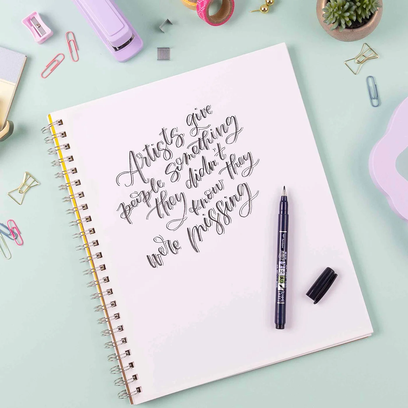 Maker lettering scene; notebook and decorative stationery are not included.