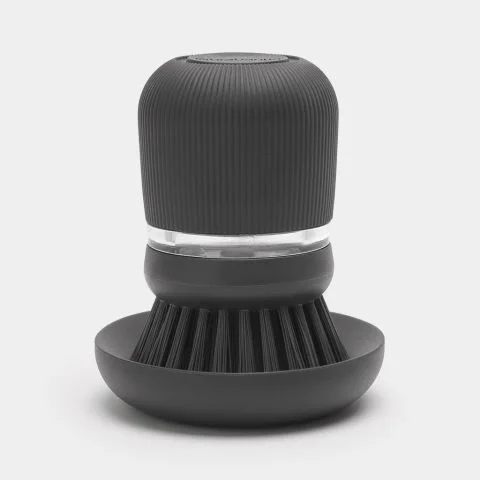 Dark-grey soap-dispensing palm brush on its stand.