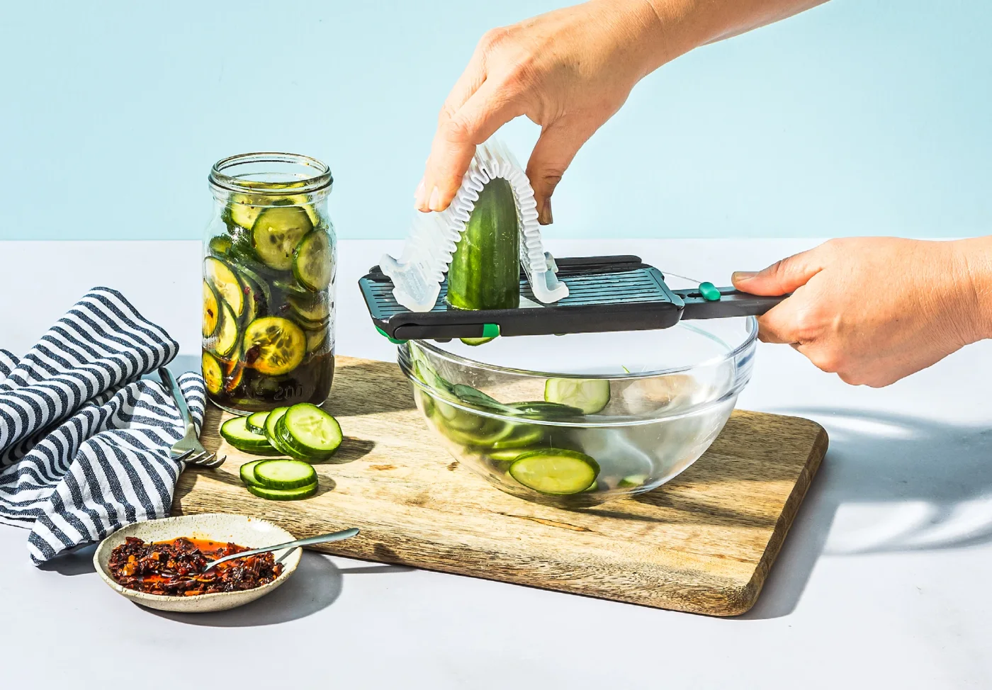 Nocutu slicing cucumber with its track-mounted guard over a bowl.