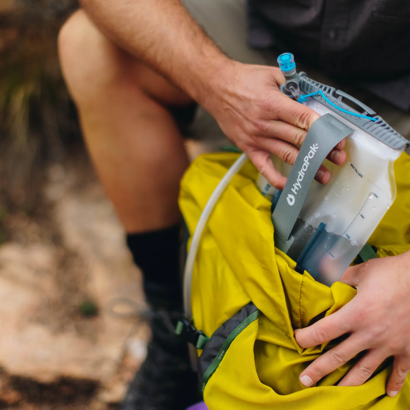 Placing the reservoir inside a compatible backpack sleeve.